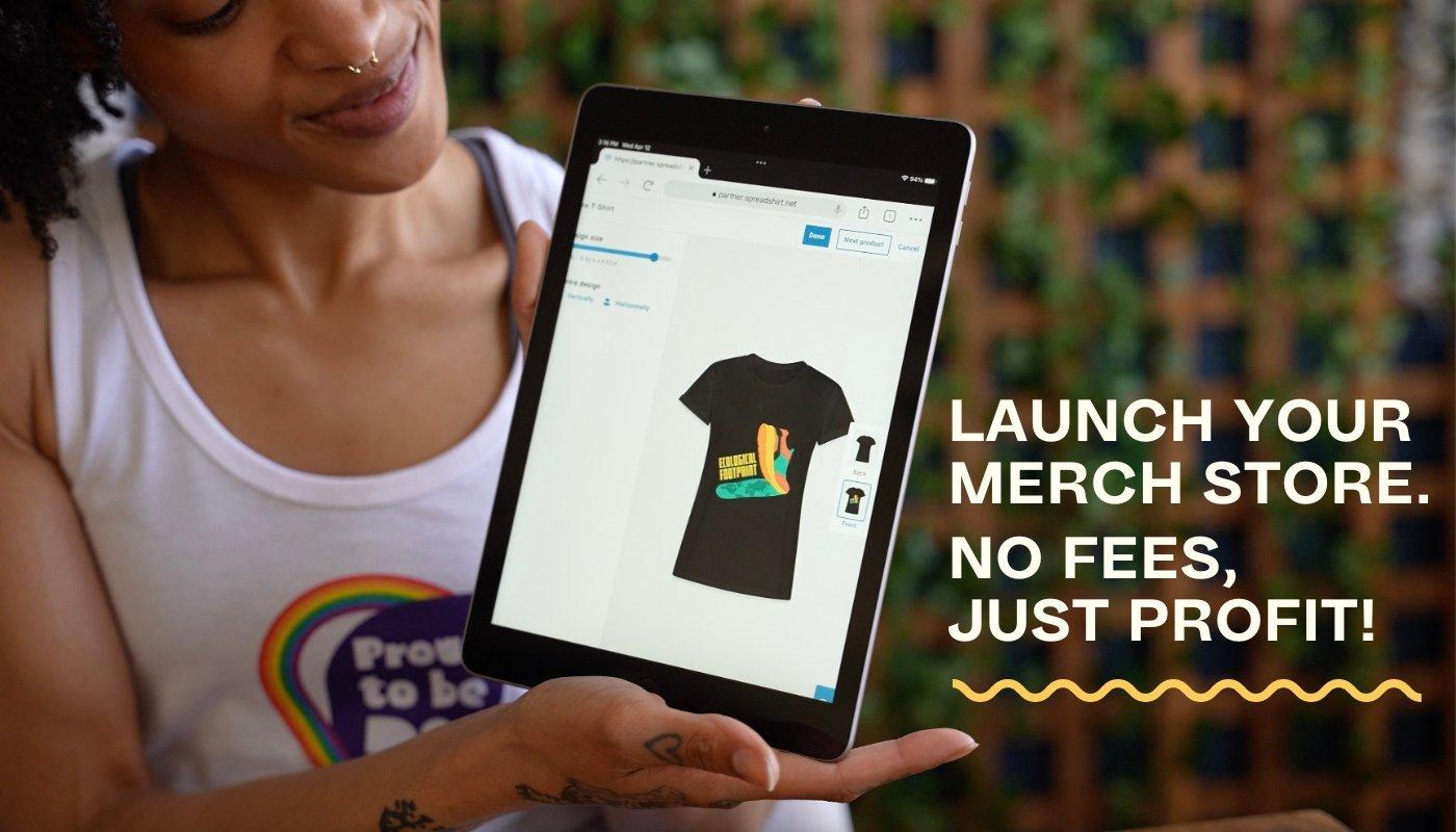 creator holding up an ipad with a t-shirt mockup in their shop